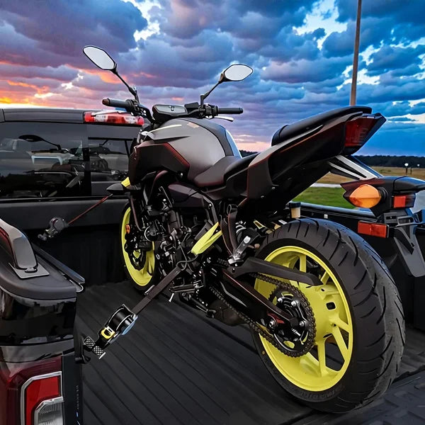 Motorcycle with yellow wheels on a car's open trunk against a sunset sky.