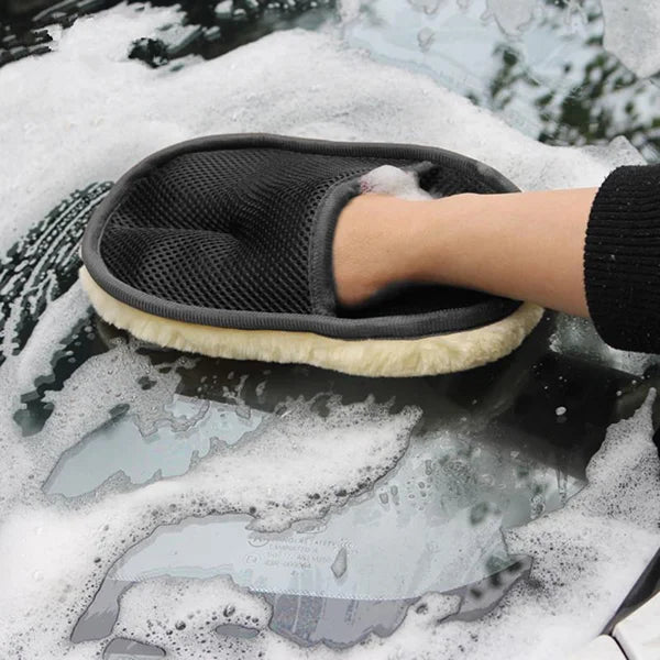 Person cleaning a car window with a soapy sponge